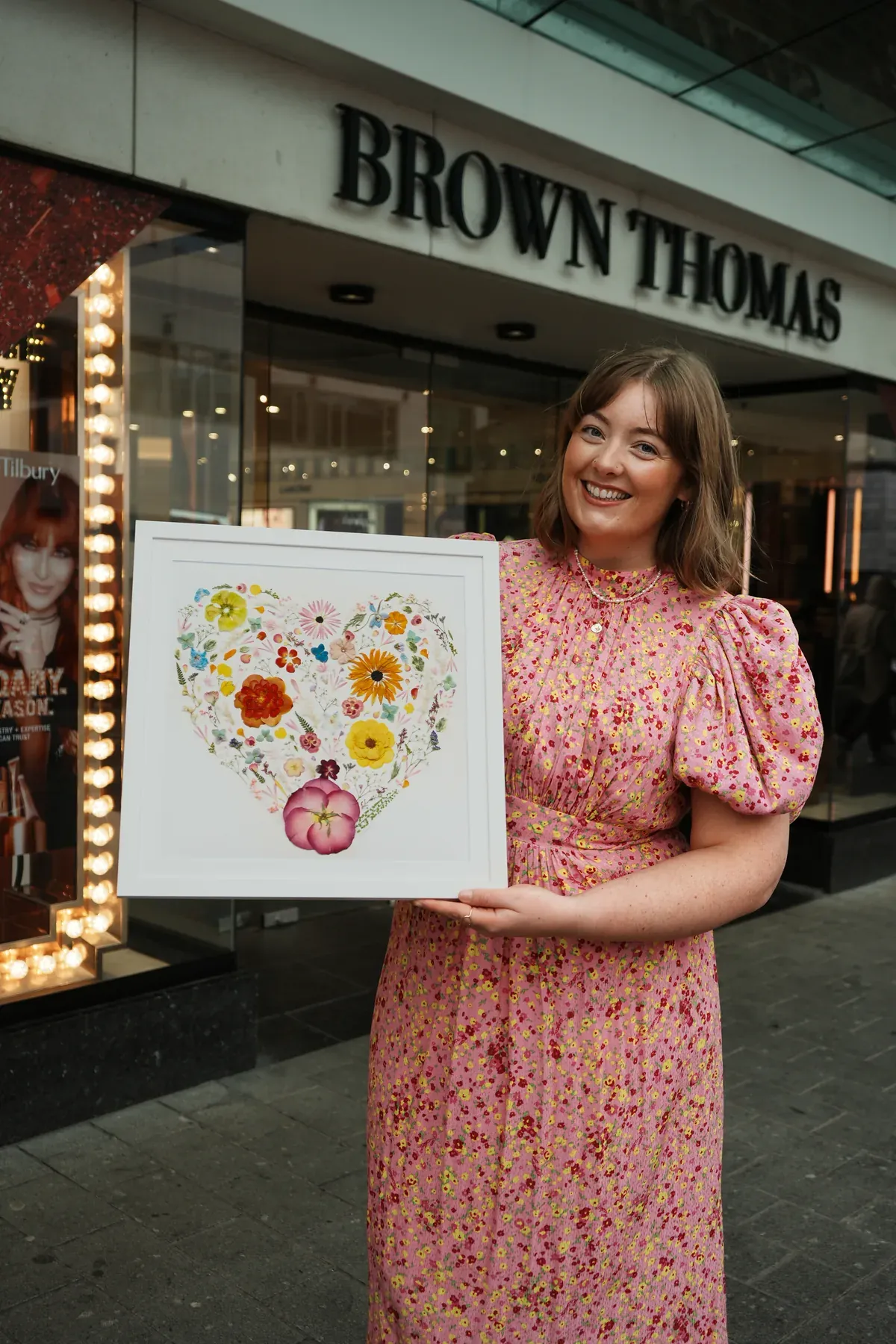 Nell outside Brown Thomas Limerick holding a pressed flower heart