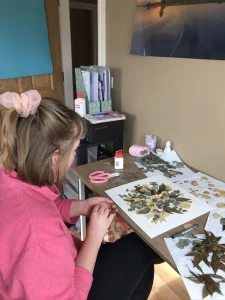 Nell pressing flowers at her desk at home
