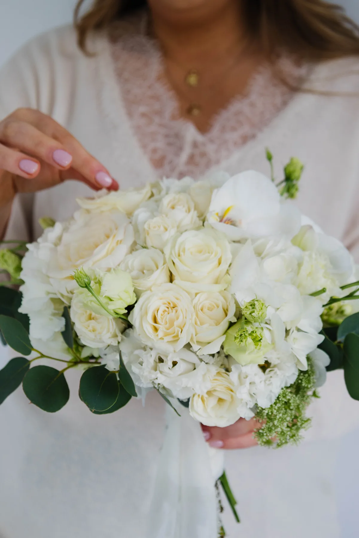 A bride holding her white rose bouquet