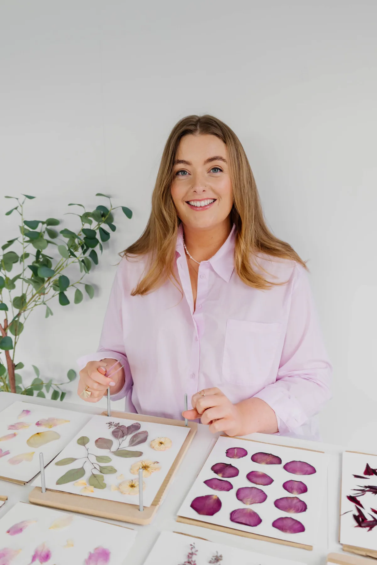 Nell arranging pressed petals at her studio table