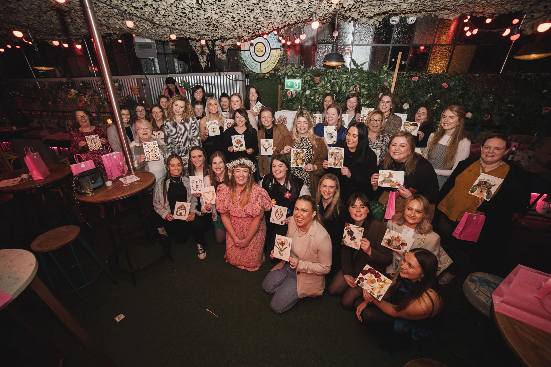A hen party group holding their finished pressed flower artwork