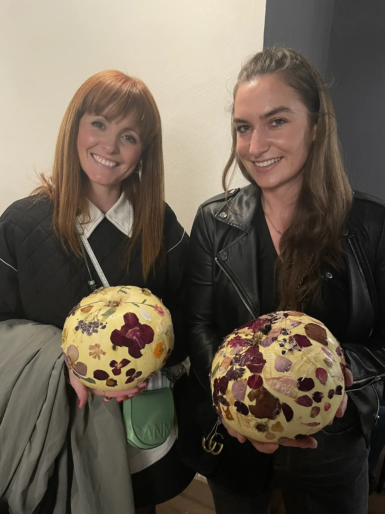 Two friends holding the pressed flower pieces they made