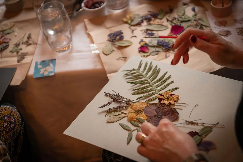 A finished pressed fern and flower artwork on the workshop table