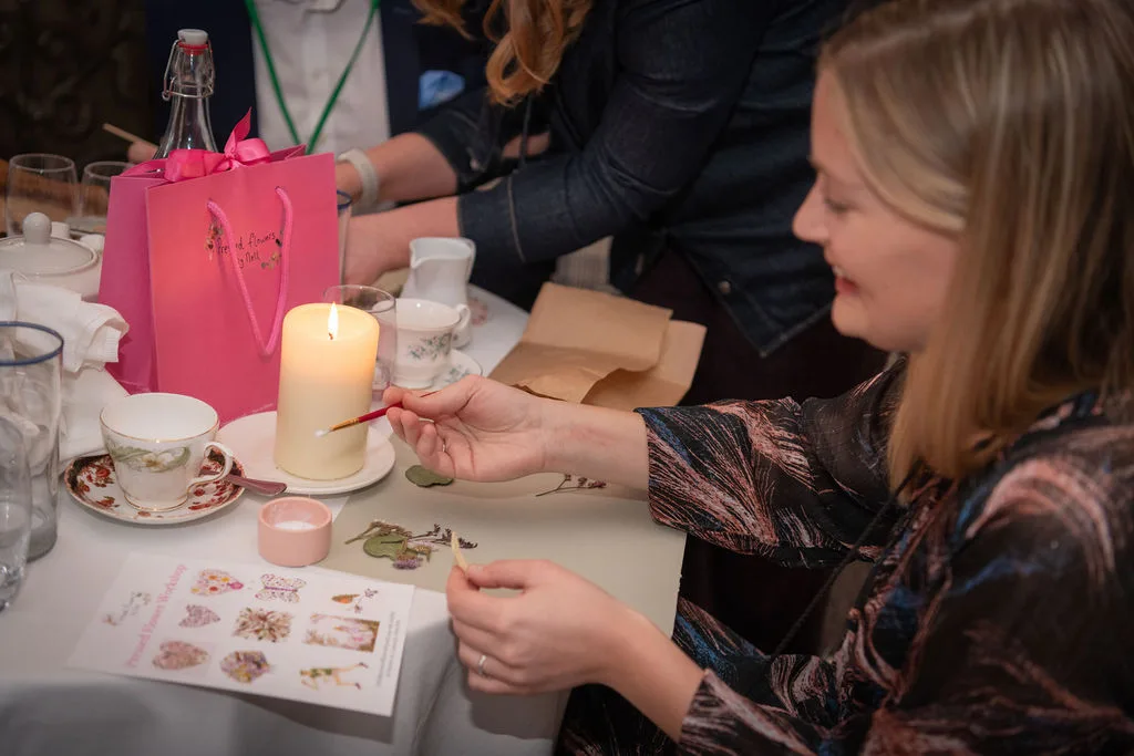 A guest painting quietly by candlelight at a workshop