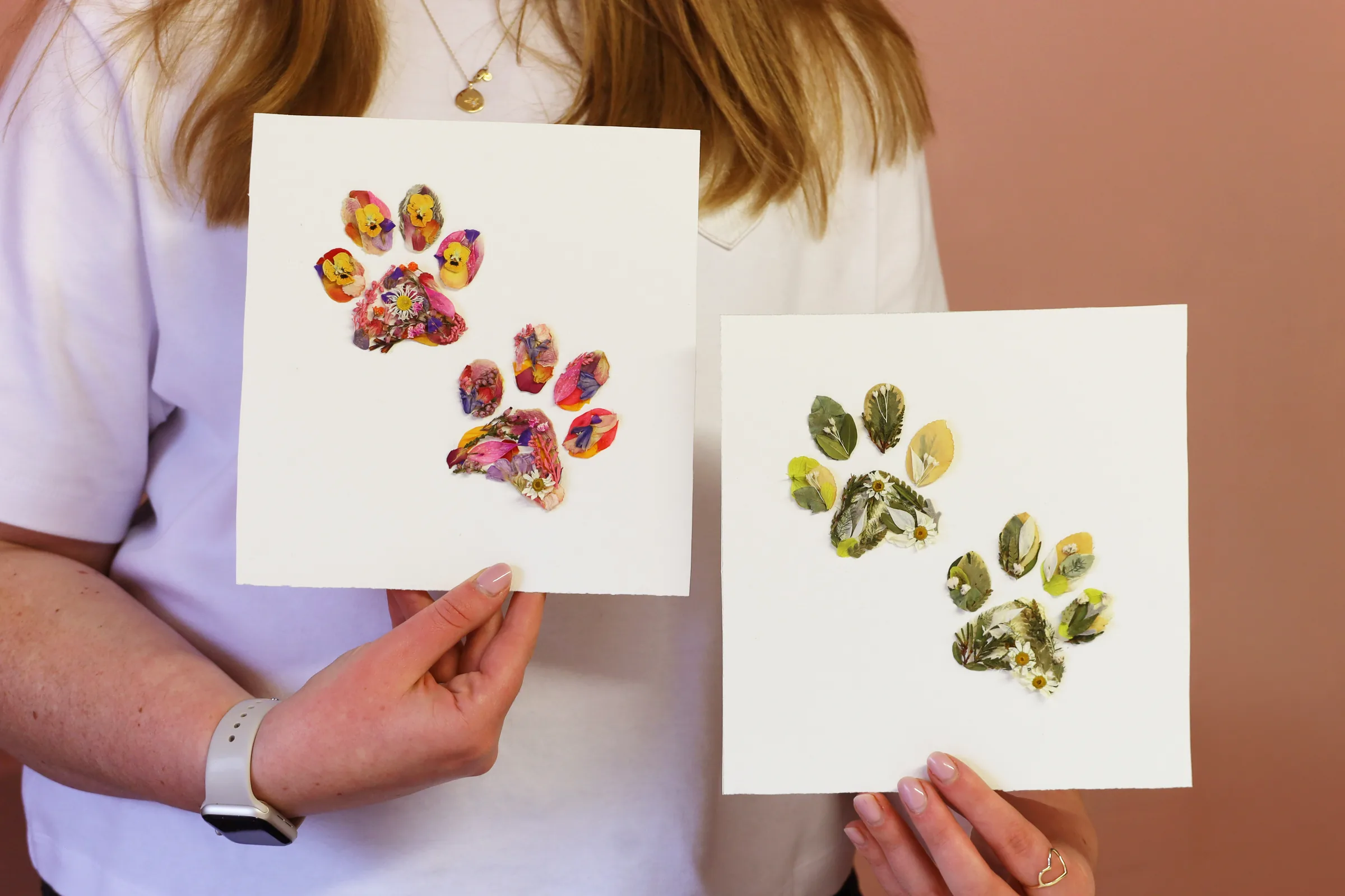 Nell holding two pressed flower paw print designs