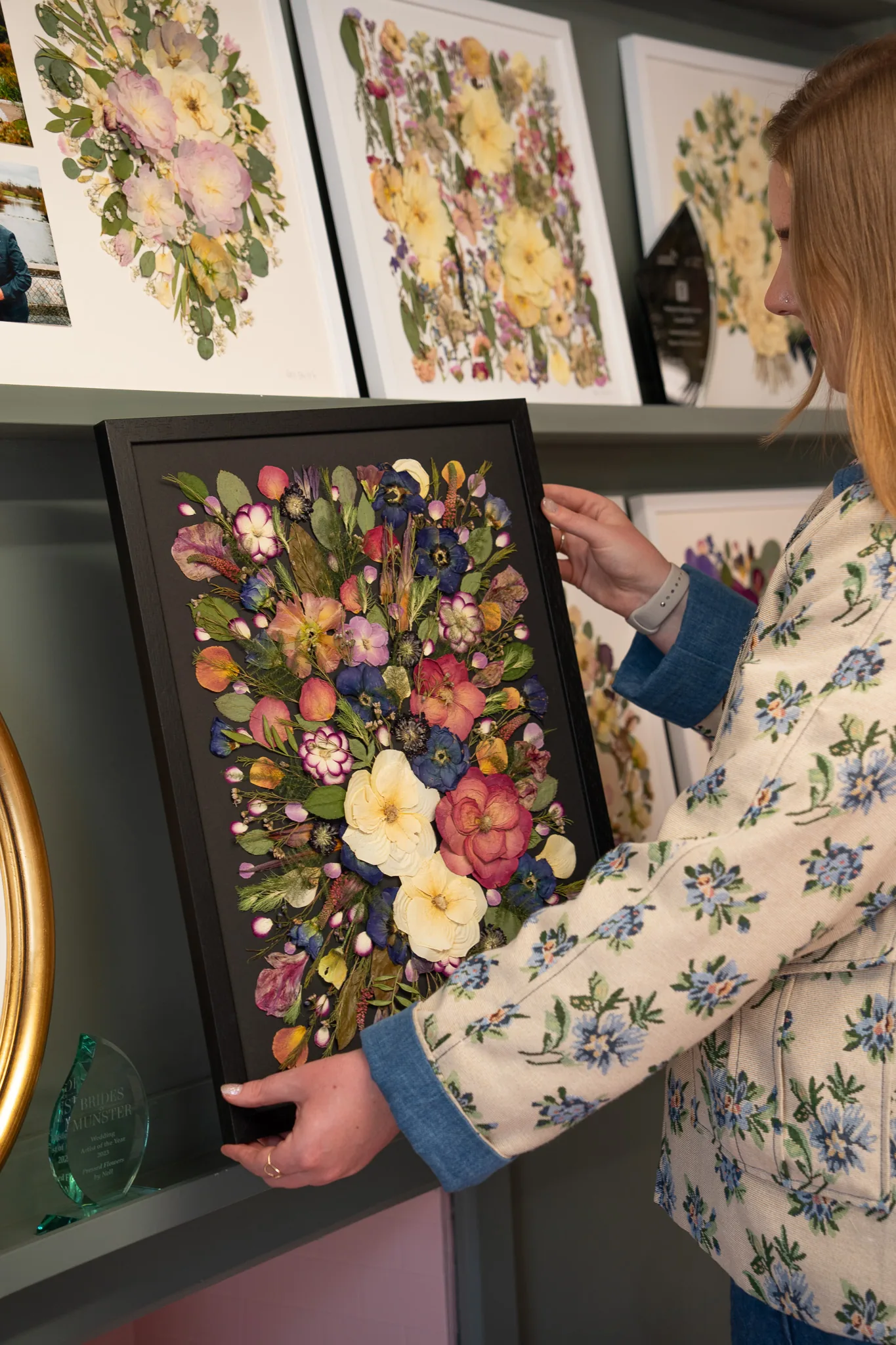 A framed pressed flower bouquet in a black frame