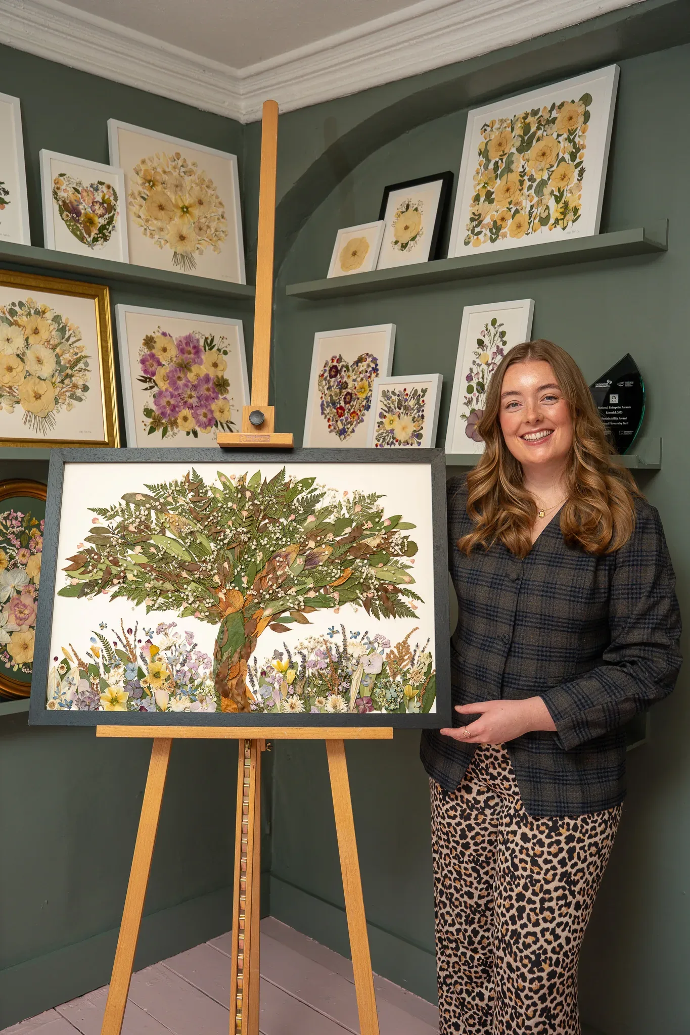 Nell beside a framed pressed flower tree
