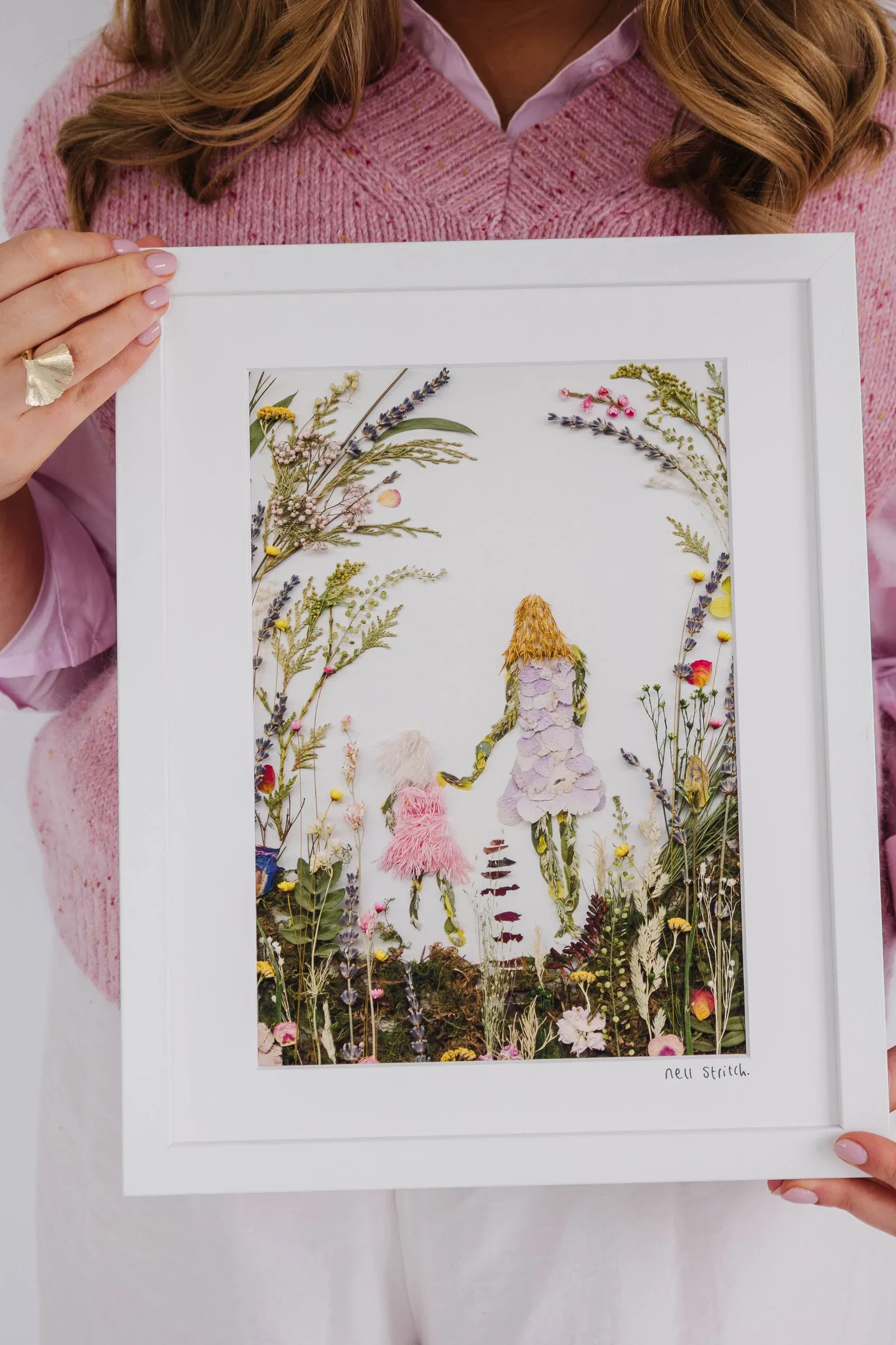A framed pressed flower design of a mother and daughter