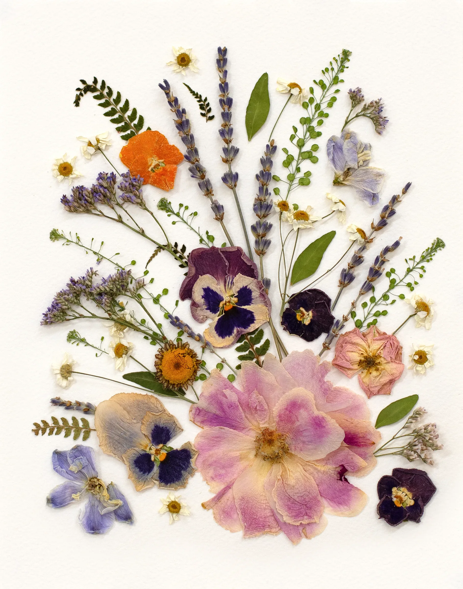 A pressed wildflower bouquet with pansies, lavender and roses