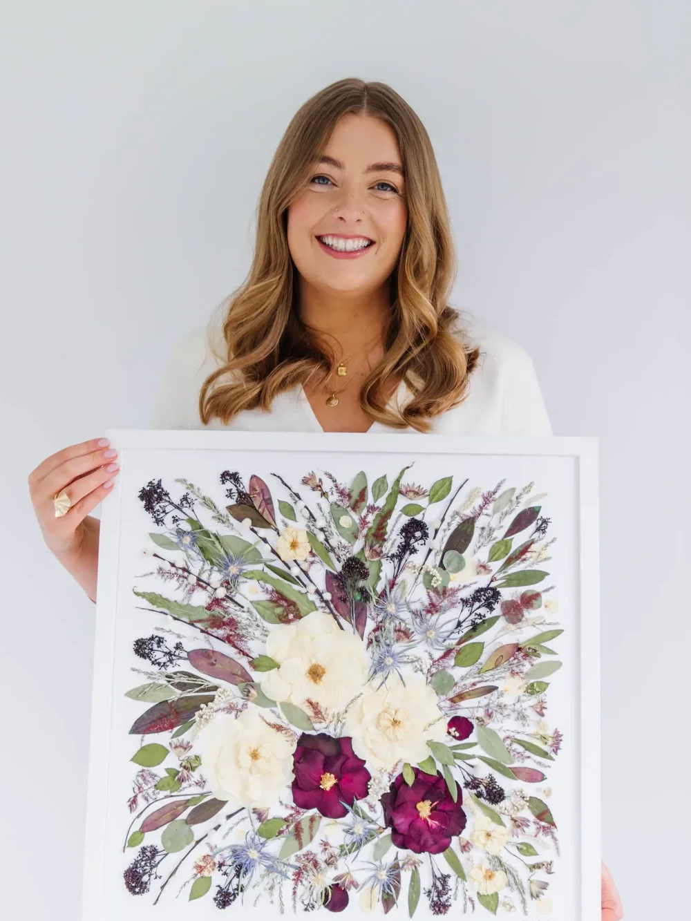 Nell smiling, holding a square pressed bouquet design