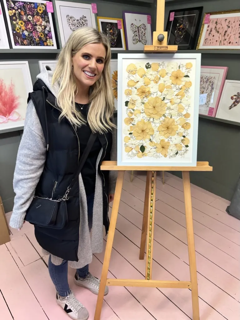 A happy bride with her framed pressed wedding bouquet