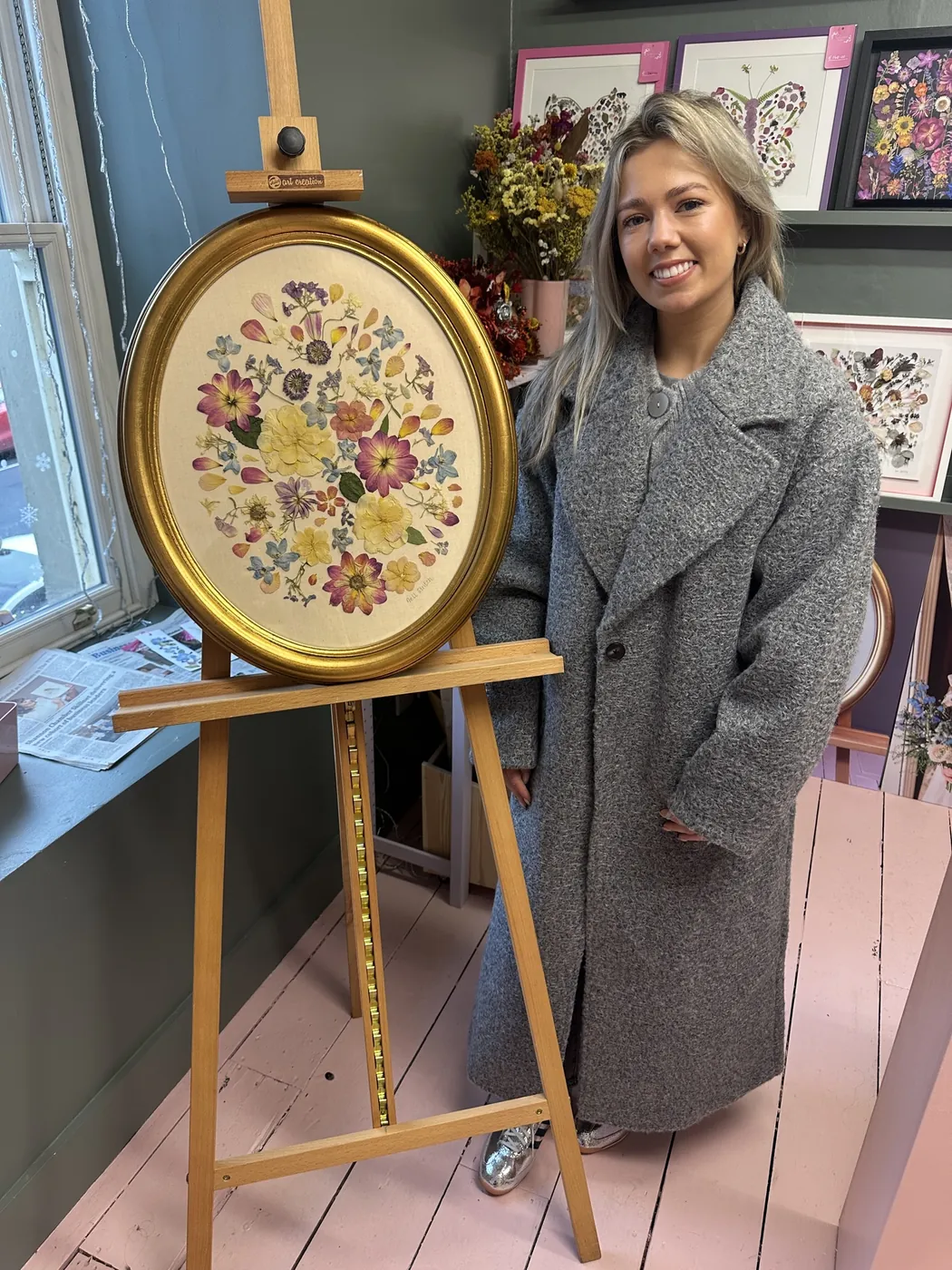 A happy bride with her framed pressed wedding bouquet