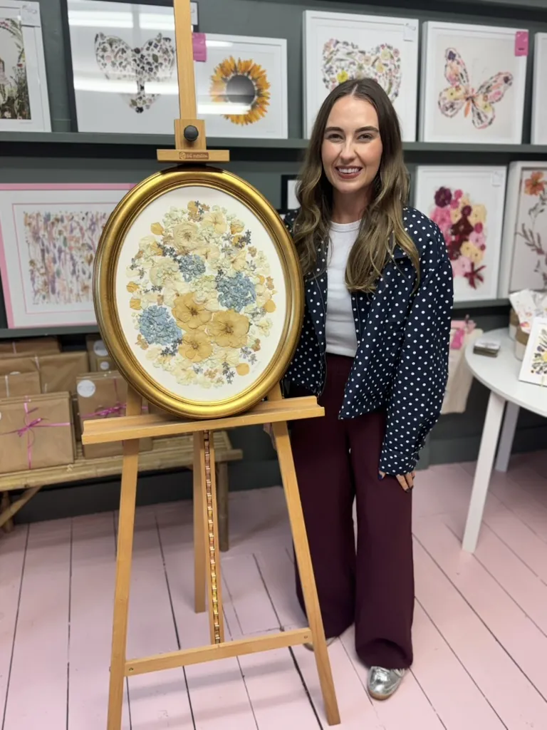 A happy bride with her framed pressed wedding bouquet
