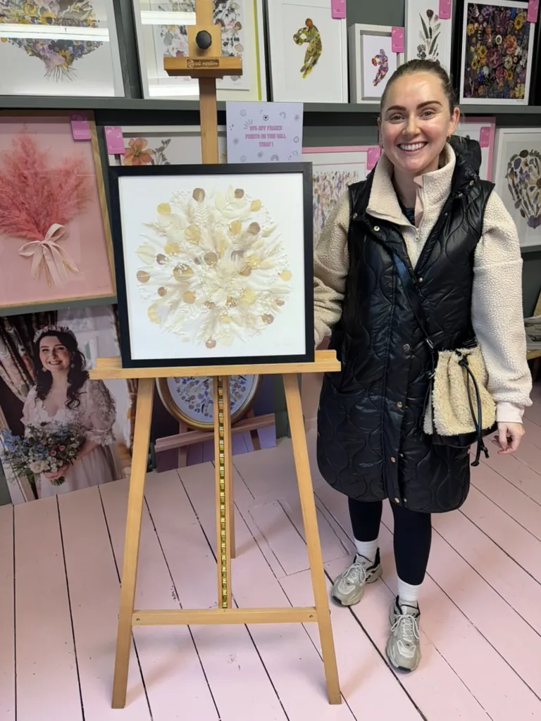 A happy bride with her framed pressed wedding bouquet
