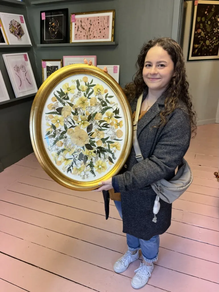 A happy bride with her framed pressed wedding bouquet