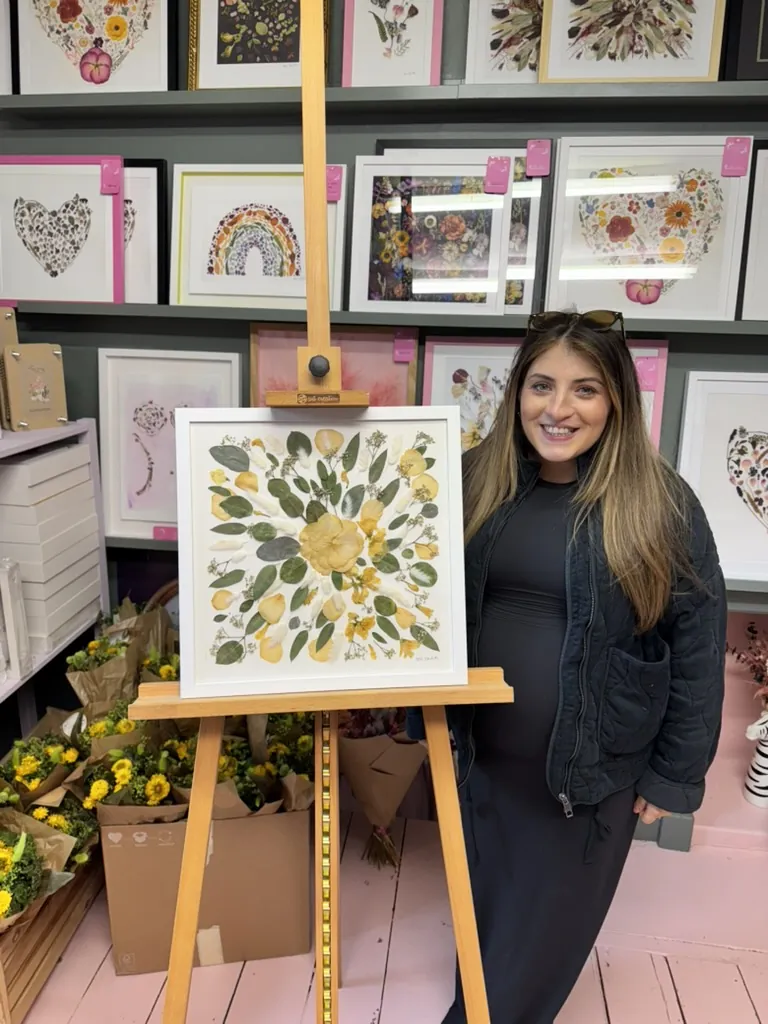 A happy bride with her framed pressed wedding bouquet