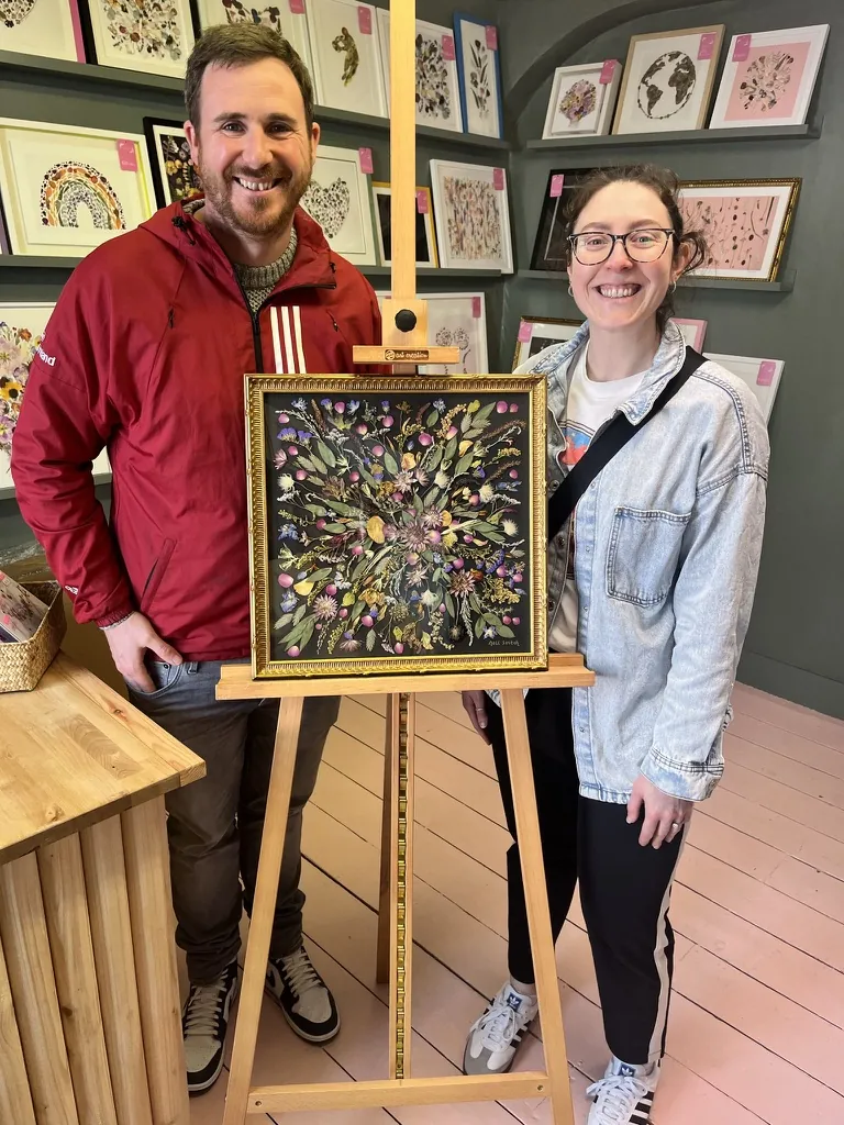 A happy bride with her framed pressed wedding bouquet