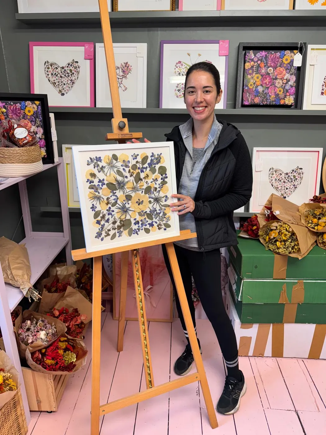 A happy bride with her framed pressed wedding bouquet