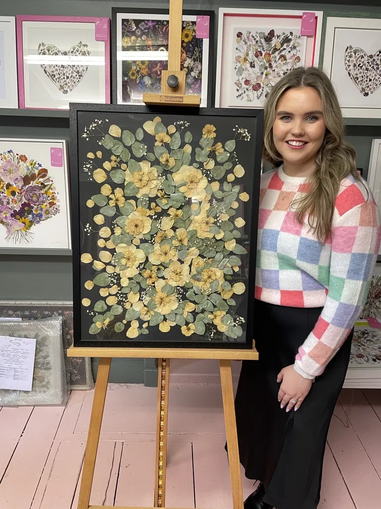 A happy bride with her framed pressed wedding bouquet
