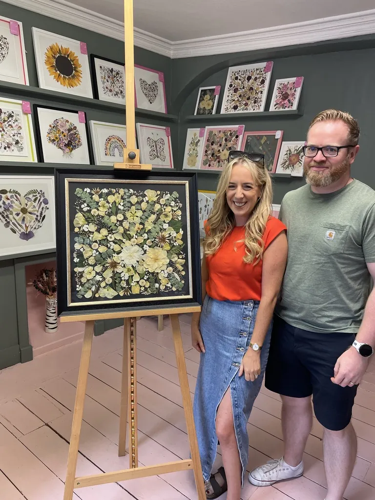 A happy bride with her framed pressed wedding bouquet