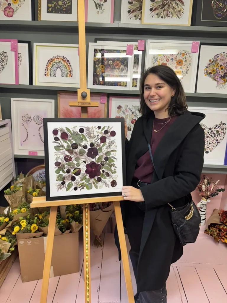 A happy bride with her framed pressed wedding bouquet