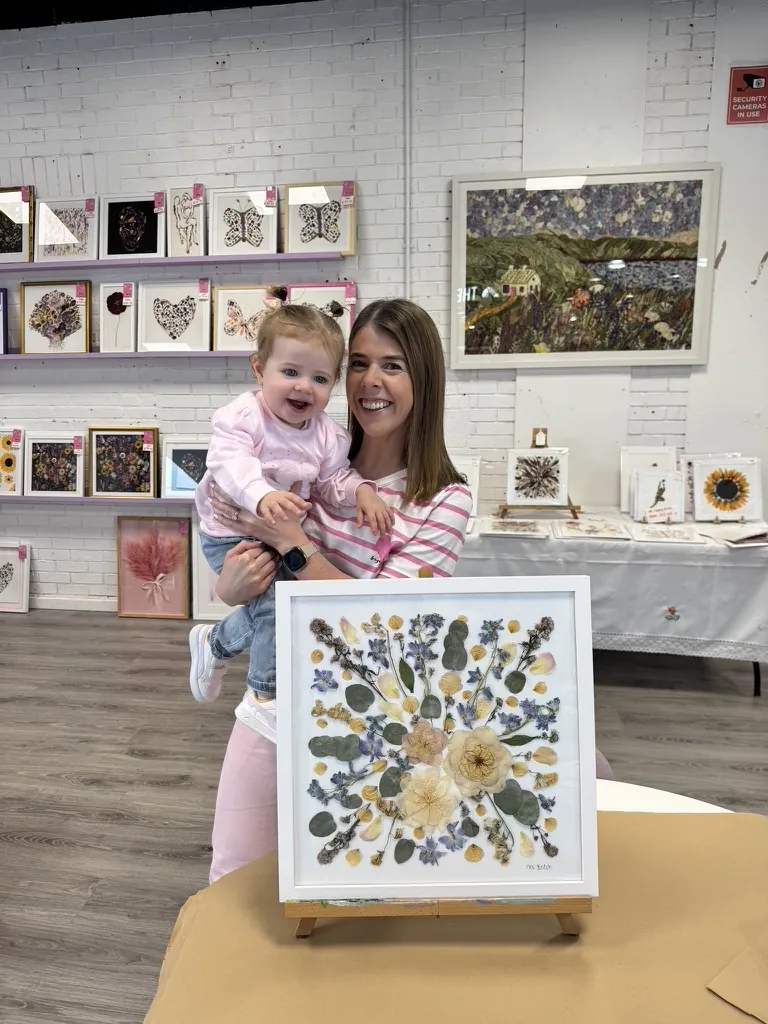 A happy bride with her framed pressed wedding bouquet