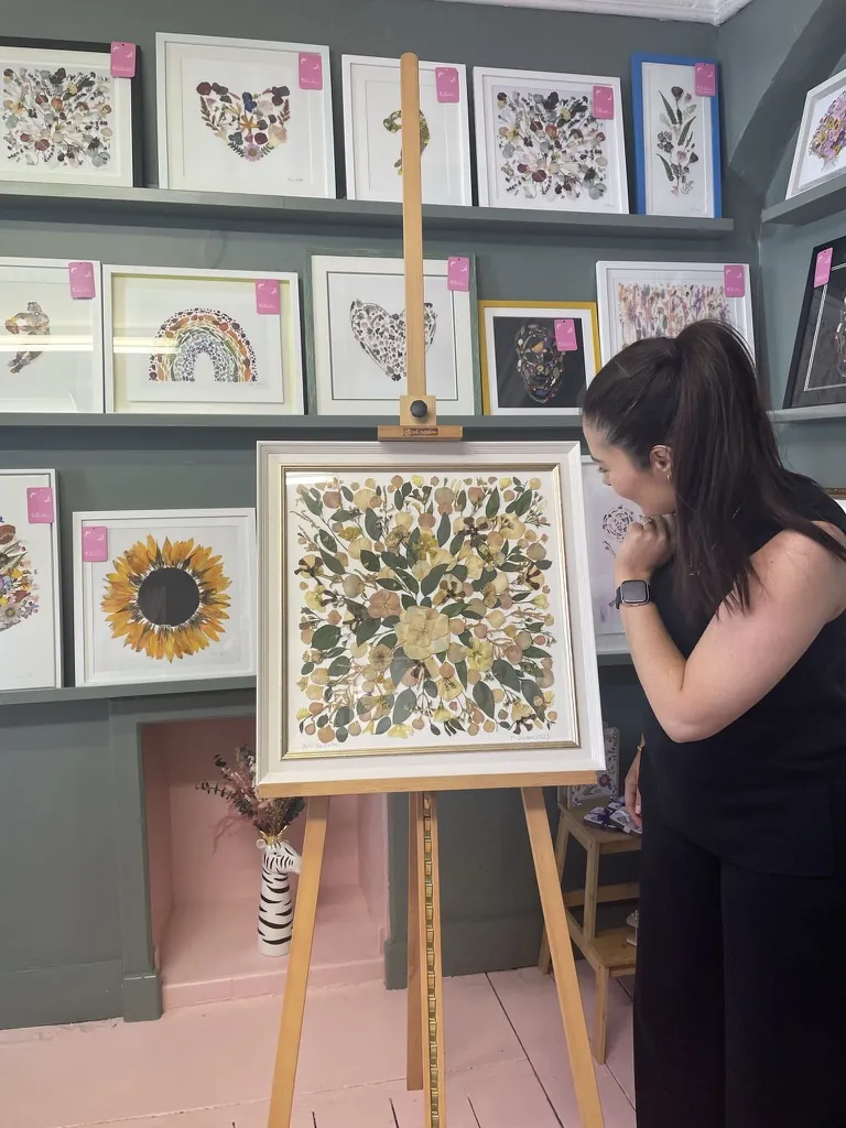 A happy bride with her framed pressed wedding bouquet