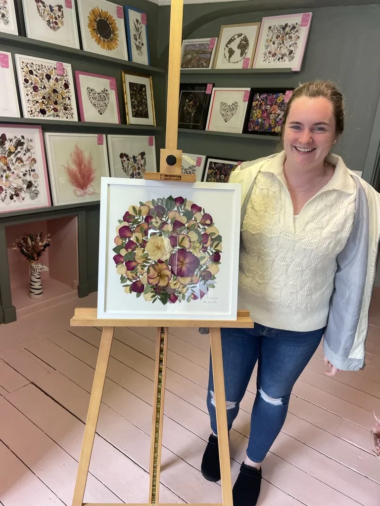 A happy bride with her framed pressed wedding bouquet