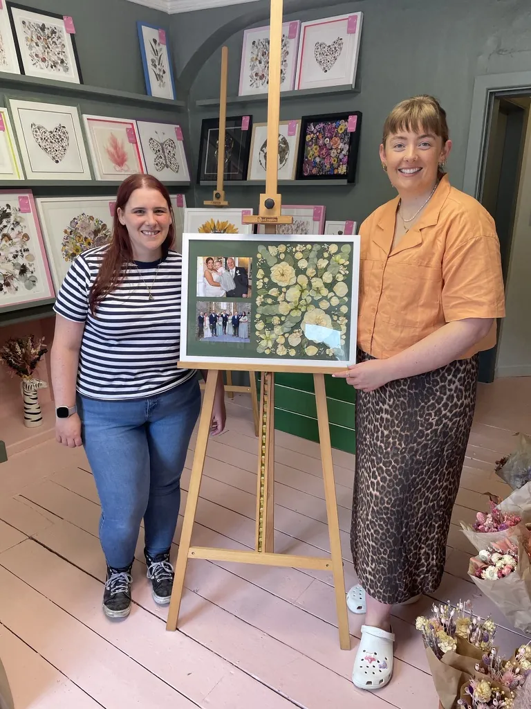 A happy bride with her framed pressed wedding bouquet