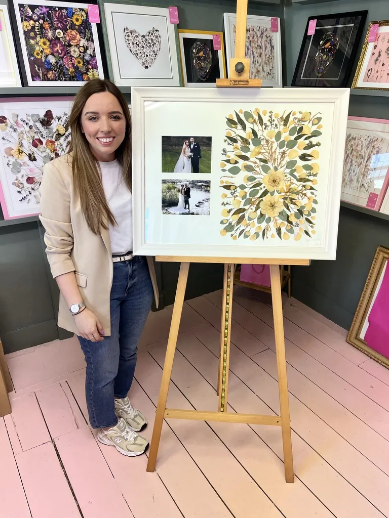 A happy bride with her framed pressed wedding bouquet