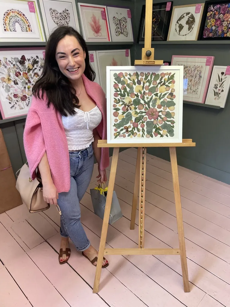 A happy bride with her framed pressed wedding bouquet