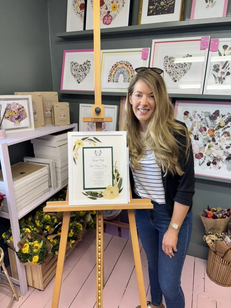 A happy bride with her framed pressed wedding bouquet