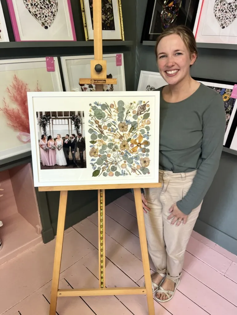 A happy bride with her framed pressed wedding bouquet