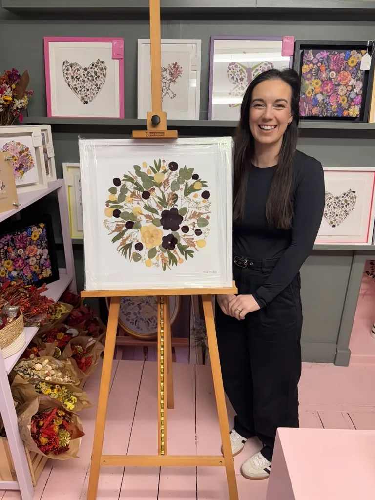 A happy bride with her framed pressed wedding bouquet