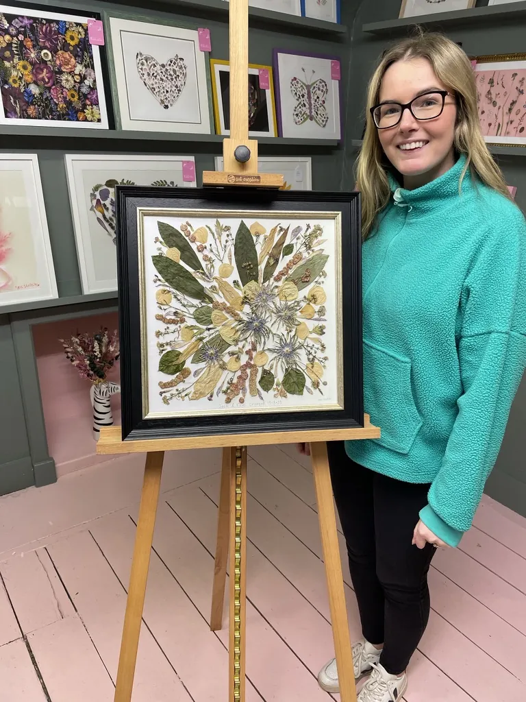 A happy bride with her framed pressed wedding bouquet