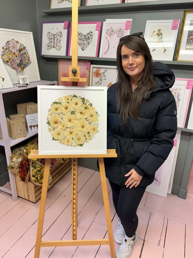 A happy bride with her framed pressed wedding bouquet