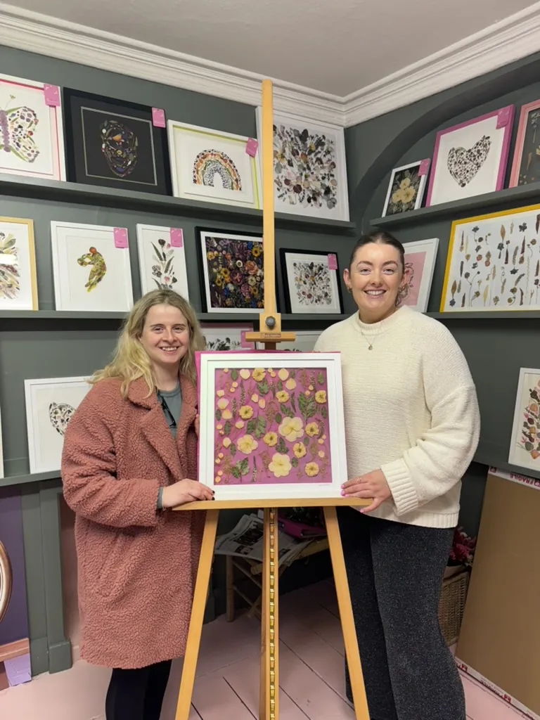 A happy bride with her framed pressed wedding bouquet