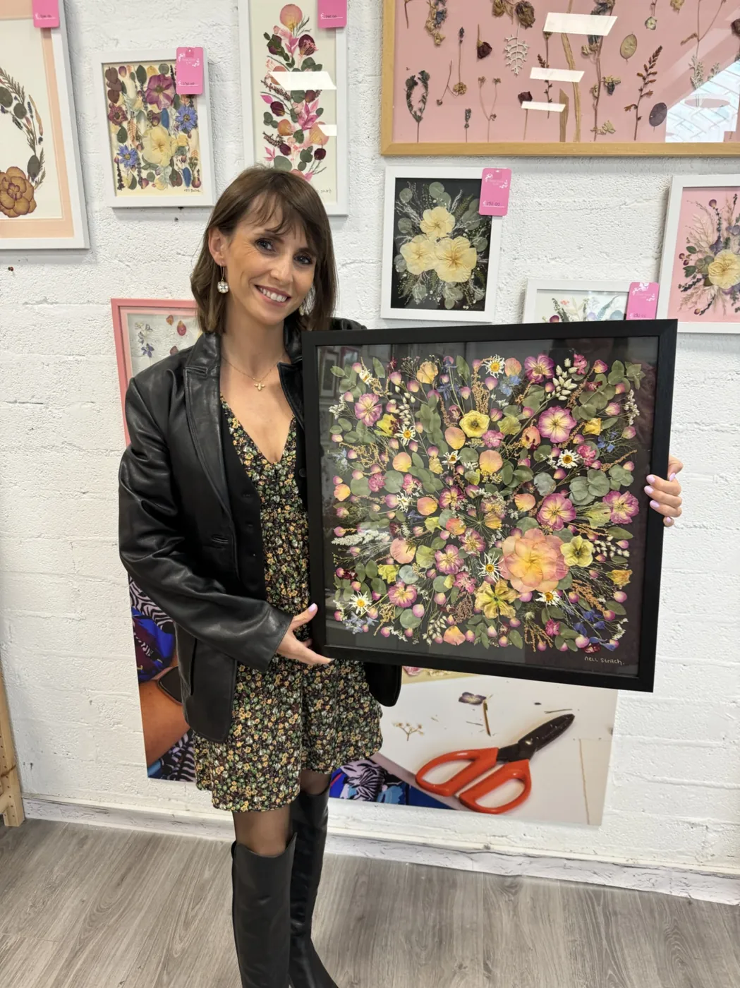 A happy bride with her framed pressed wedding bouquet