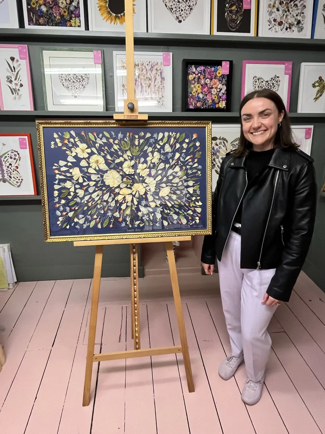 A happy bride with her framed pressed wedding bouquet