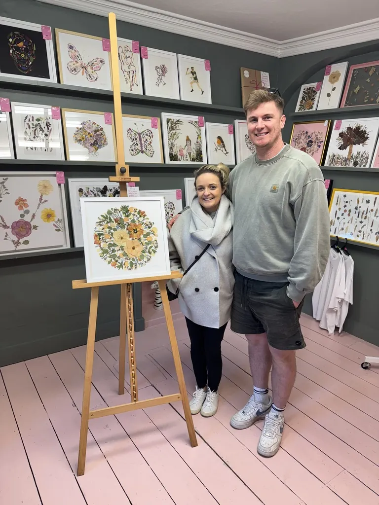 A happy bride with her framed pressed wedding bouquet