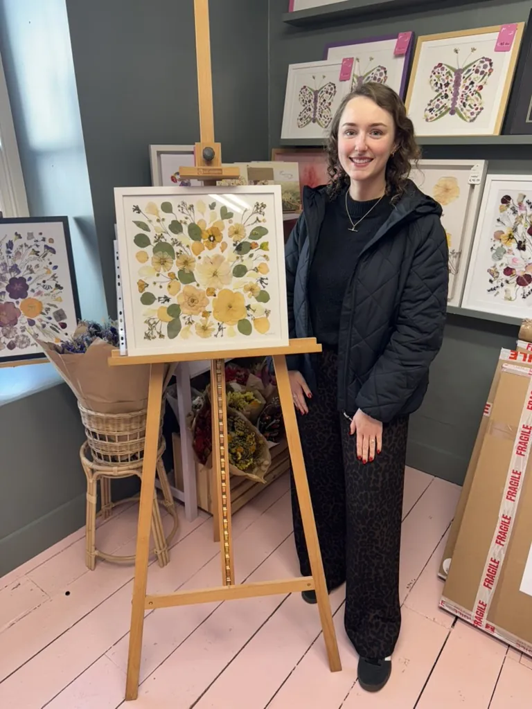 A happy bride with her framed pressed wedding bouquet