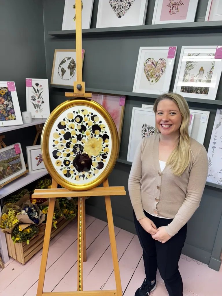 A happy bride with her framed pressed wedding bouquet