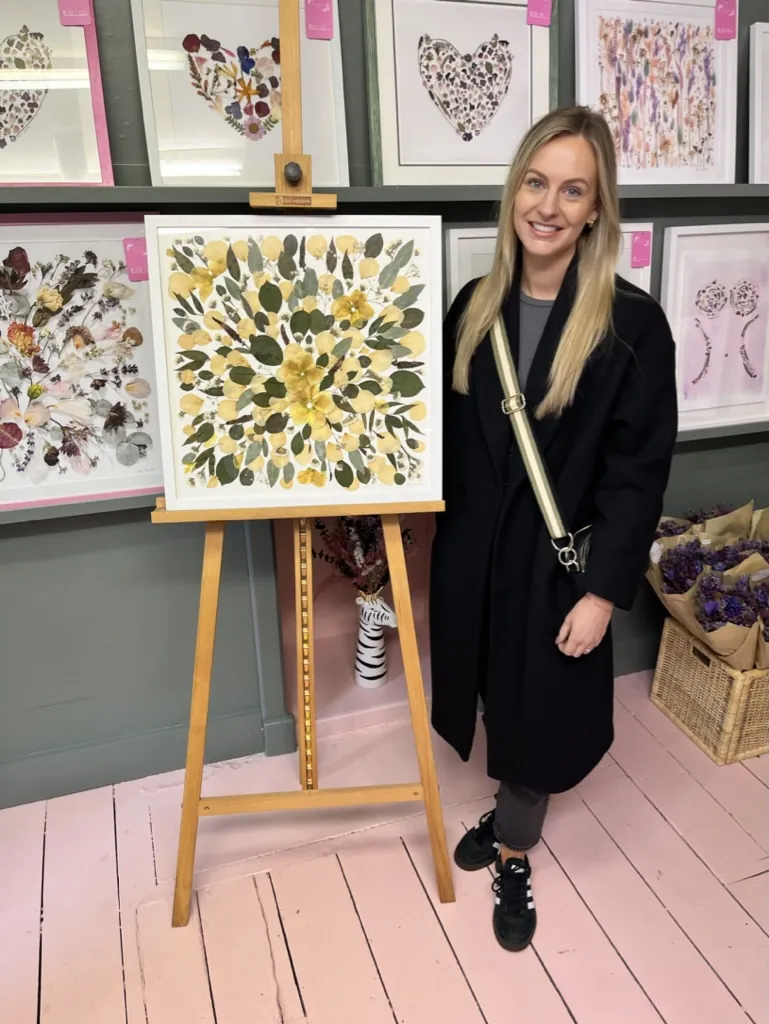 A happy bride with her framed pressed wedding bouquet