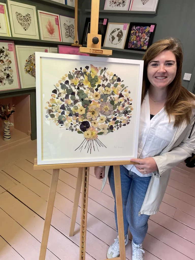 A happy bride with her framed pressed wedding bouquet