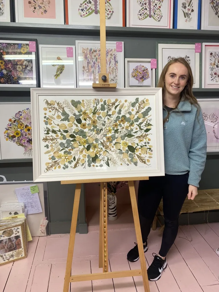 A happy bride with her framed pressed wedding bouquet