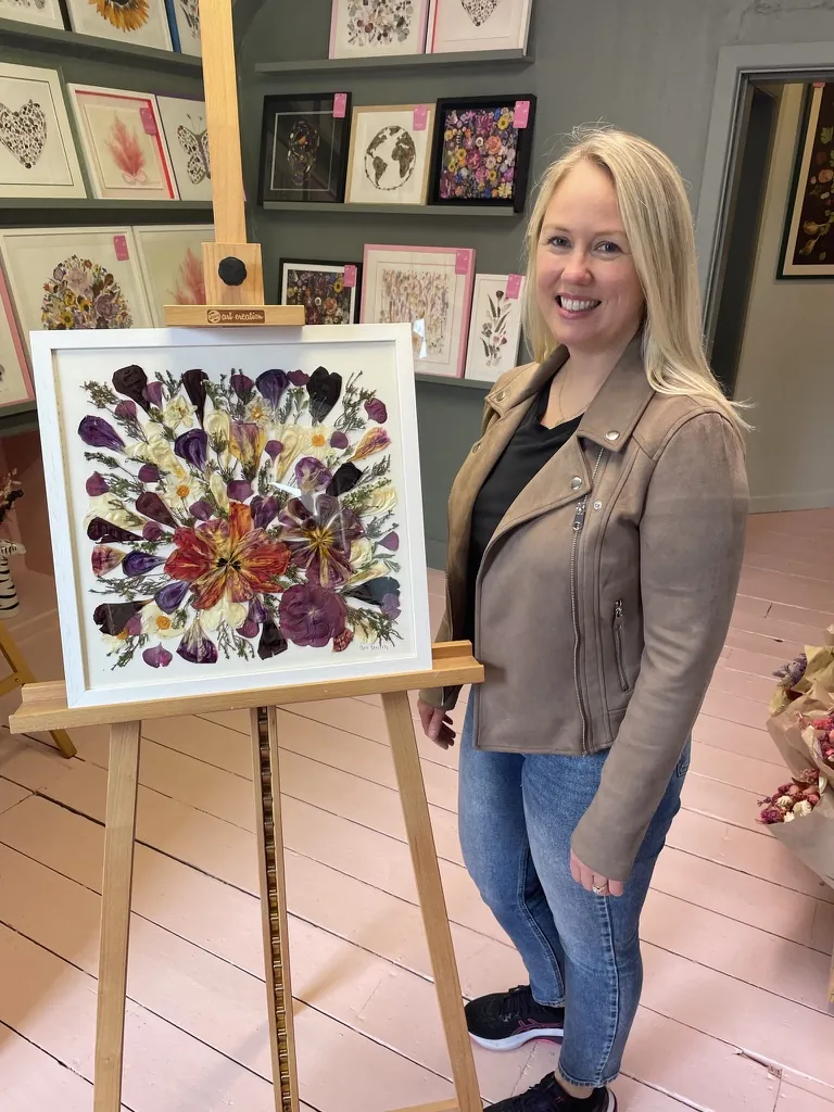 A happy bride with her framed pressed wedding bouquet