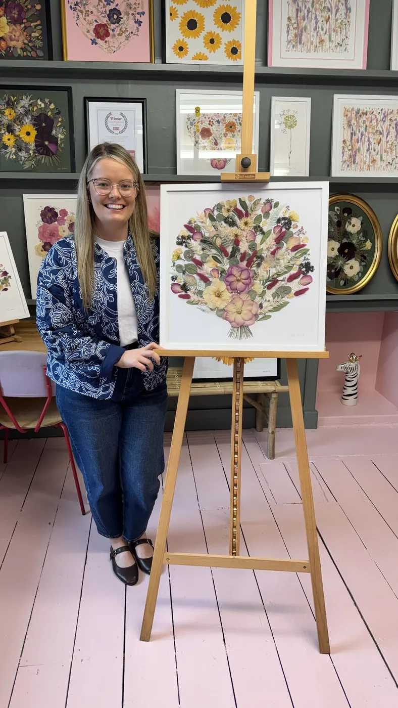 A happy bride with her framed pressed wedding bouquet