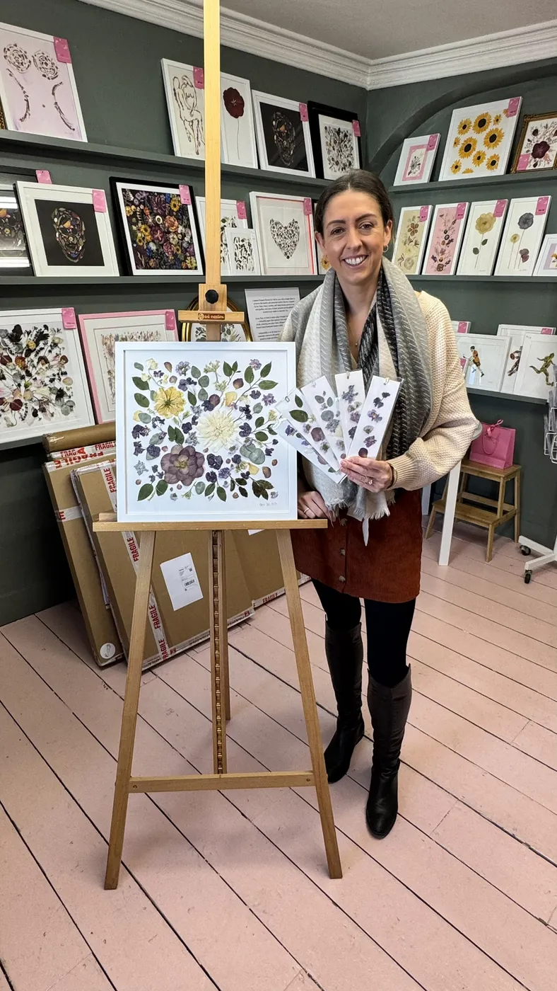 A happy bride with her framed pressed wedding bouquet