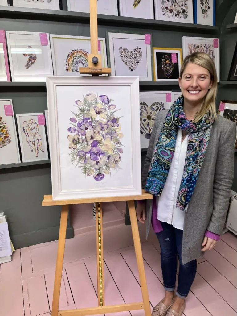A happy bride with her framed pressed wedding bouquet