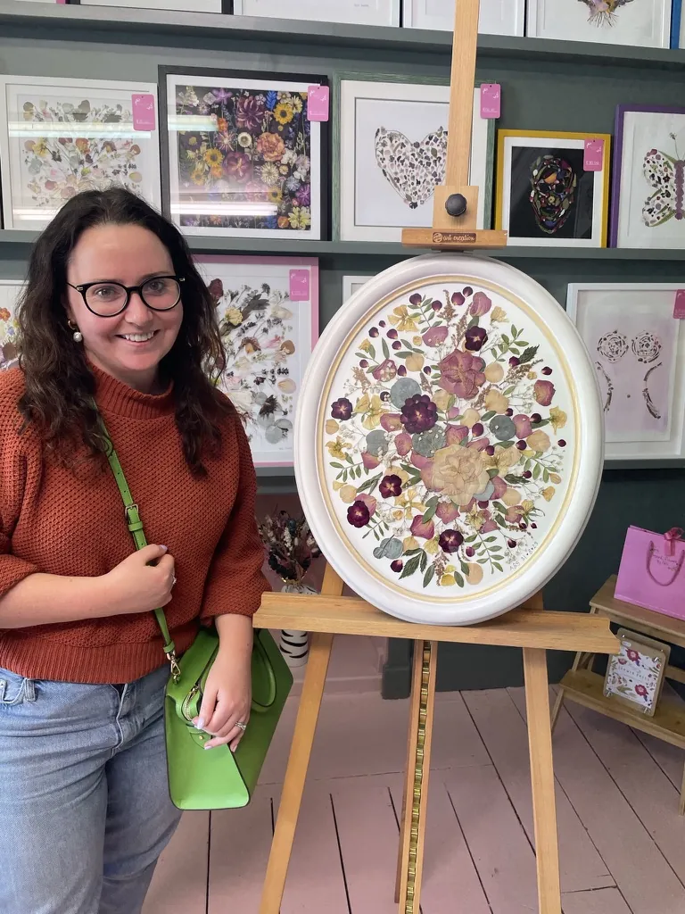 A happy bride with her framed pressed wedding bouquet